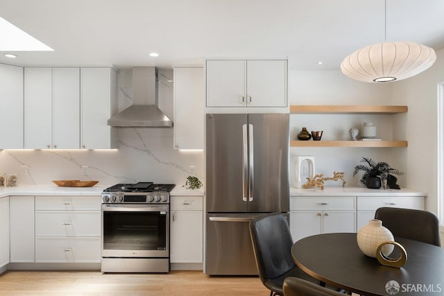 69 Lobos St, San Francisco, CA 94112 - kitchen featuring stainless steel appliances, wall chimney exhaust hood, light countertops, white cabinets, and recessed lighting