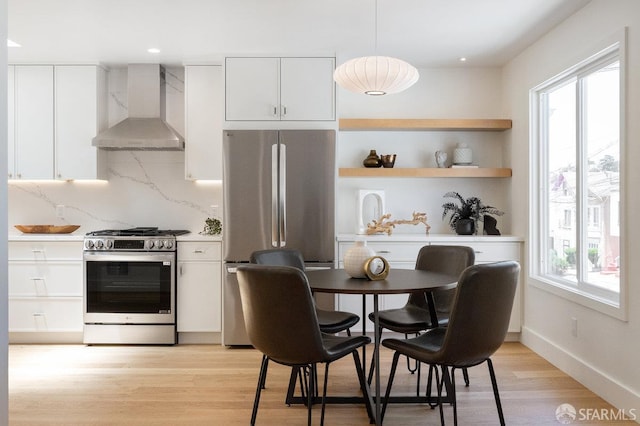 69 Lobos St, San Francisco, CA 94112 - kitchen featuring stainless steel appliances, wall chimney range hood, tasteful backsplash, white cabinetry, and recessed lighting