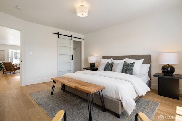 69 Lobos St, San Francisco, CA 94112 - bedroom with a barn door and light wood-style floors