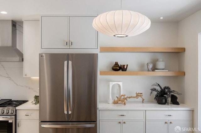 69 Lobos St, San Francisco, CA 94112 - kitchen with appliances with stainless steel finishes, wall chimney range hood, open shelves, white cabinetry, and light stone counters