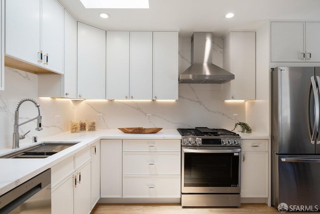 69 Lobos St, San Francisco, CA 94112 - kitchen with appliances with stainless steel finishes, wall chimney range hood, tasteful backsplash, white cabinetry, and recessed lighting