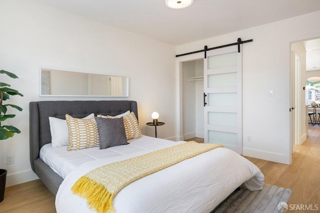 69 Lobos St, San Francisco, CA 94112 - bedroom featuring a barn door, light wood-style floors, and a closet