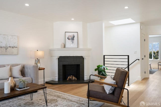 69 Lobos St, San Francisco, CA 94112 - living room featuring light wood-type flooring, a skylight, a tiled fireplace, and recessed lighting