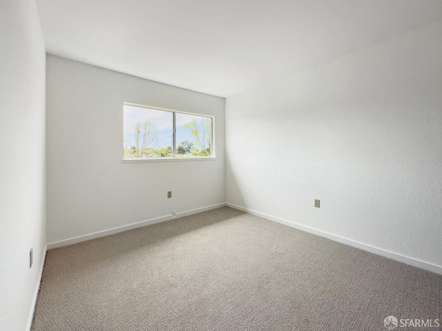 carpeted empty room with baseboards