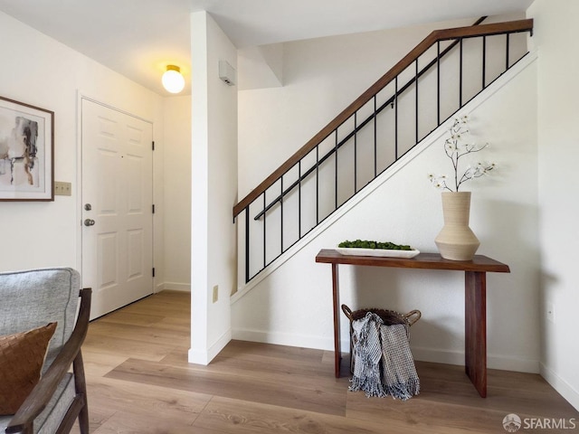 entryway with stairway, baseboards, and wood finished floors