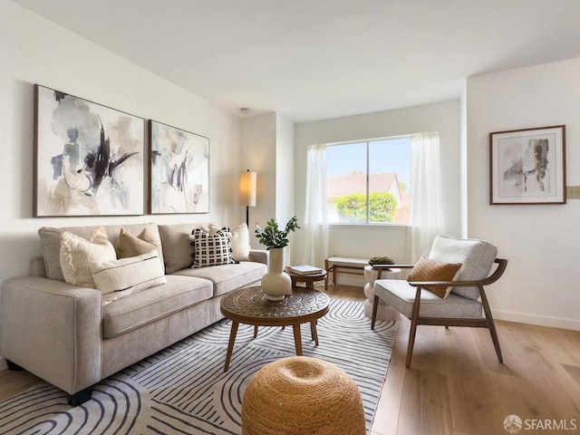 living area with light wood-type flooring and baseboards