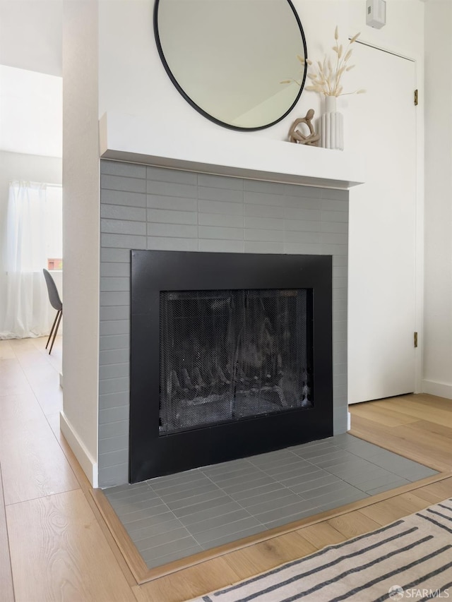 details with wood finished floors, baseboards, and a fireplace with flush hearth