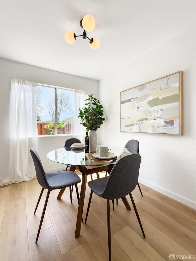 dining space featuring baseboards and wood finished floors