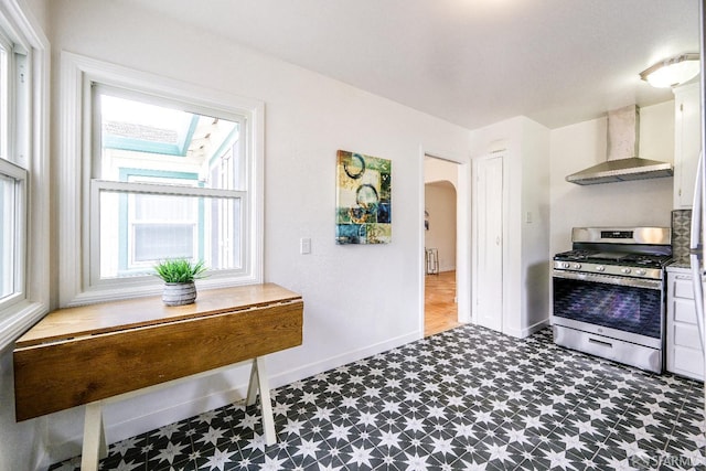 311 Linden Ave, San Bruno, CA 94066 - kitchen featuring baseboards, wall chimney range hood, dark floors, arched walkways, and gas stove