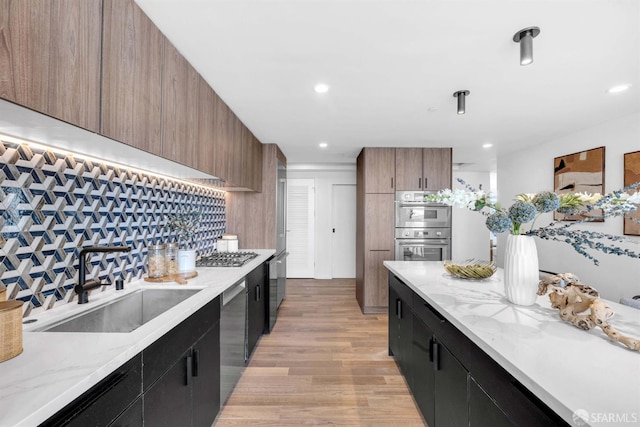 555 Fulton St Unit 519, San Francisco, CA 94102 - kitchen featuring a sink, light wood-style flooring, stainless steel appliances, dark cabinets, and recessed lighting
