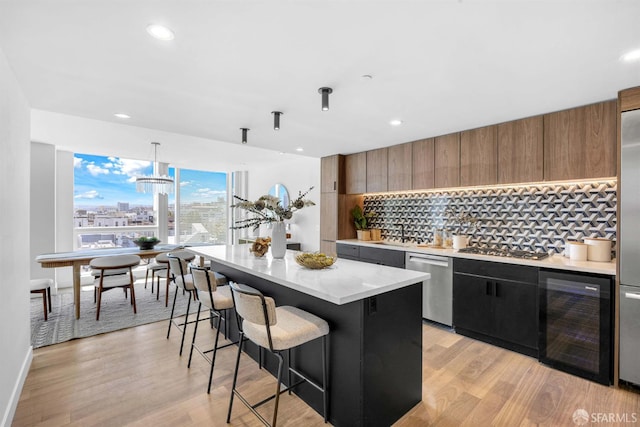 555 Fulton St Unit 519, San Francisco, CA 94102 - kitchen with beverage cooler, appliances with stainless steel finishes, modern cabinets, decorative backsplash, and a breakfast bar