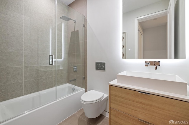 full bathroom featuring vanity, tile patterned flooring, bath / shower combo with glass door, and toilet