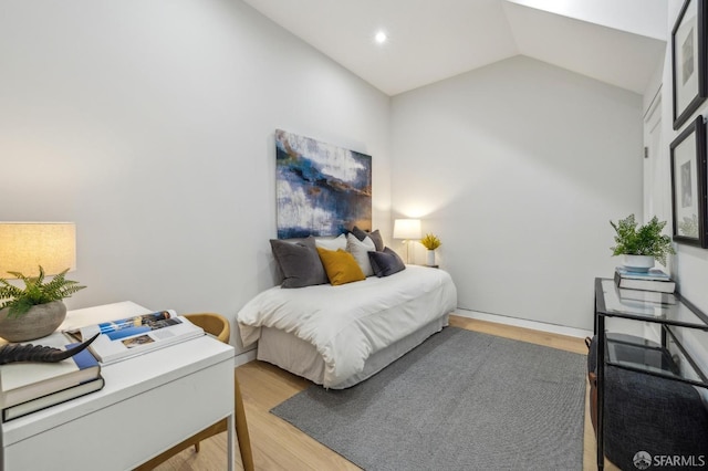 bedroom with lofted ceiling and wood-type flooring