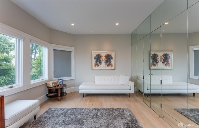 sitting room featuring baseboards, wood finished floors, and recessed lighting