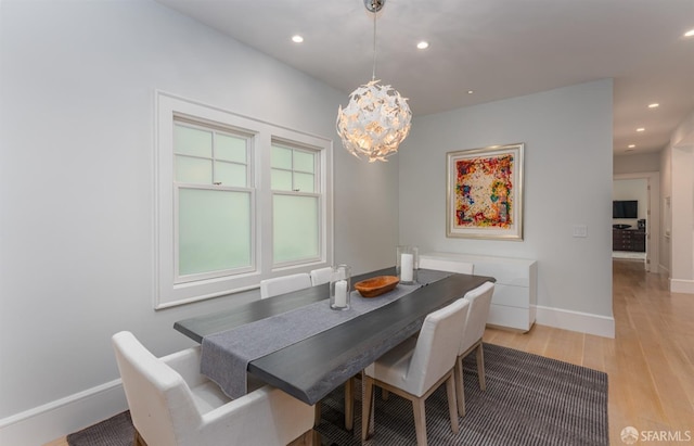 dining area with recessed lighting, baseboards, light wood-style floors, and a notable chandelier