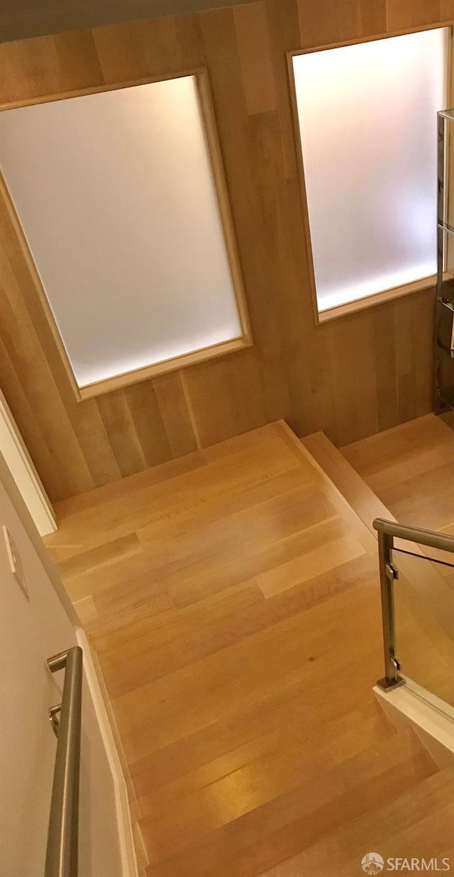 stairs with wooden walls and wood finished floors