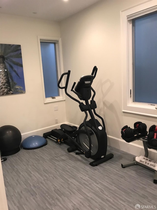 exercise room with wood finished floors and baseboards