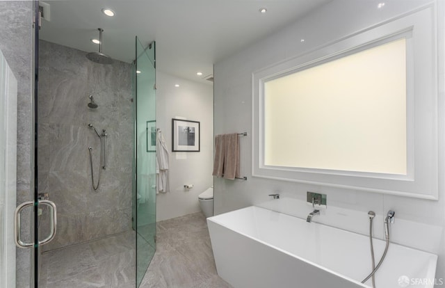 full bath with a shower stall, marble finish floor, a soaking tub, toilet, and recessed lighting