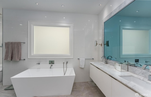 full bath featuring a soaking tub, a sink, and double vanity