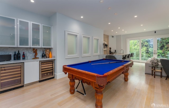 game room with recessed lighting, beverage cooler, light wood-style floors, and bar