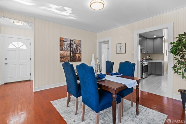 dining area with ornamental molding and light hardwood / wood-style flooring