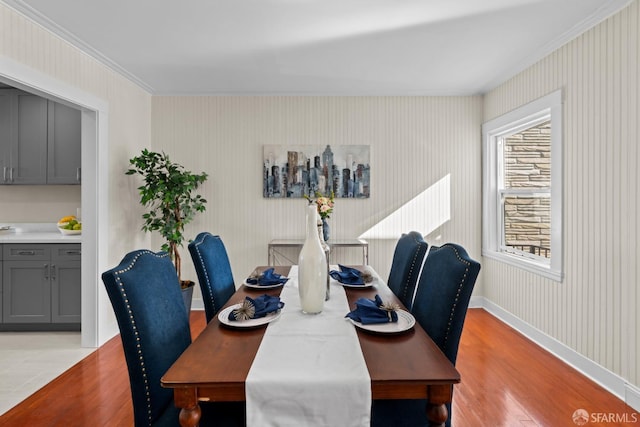 dining room featuring crown molding and light hardwood / wood-style flooring