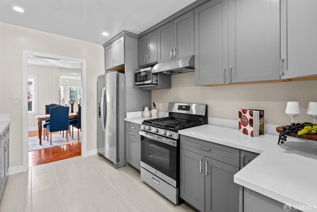 kitchen with gray cabinetry and appliances with stainless steel finishes