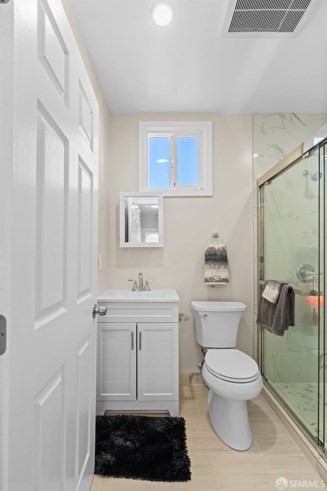 bathroom with vanity, a shower with shower door, and toilet