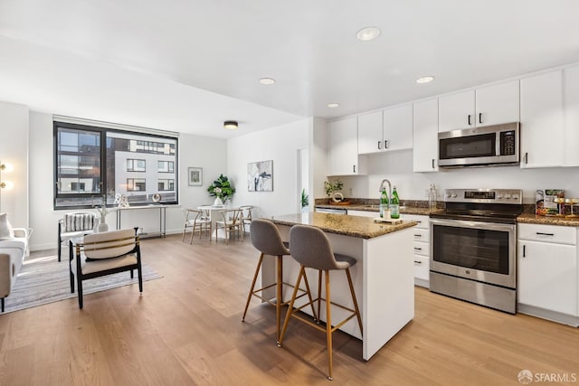 kitchen with a center island, white cabinetry, and stainless steel appliances