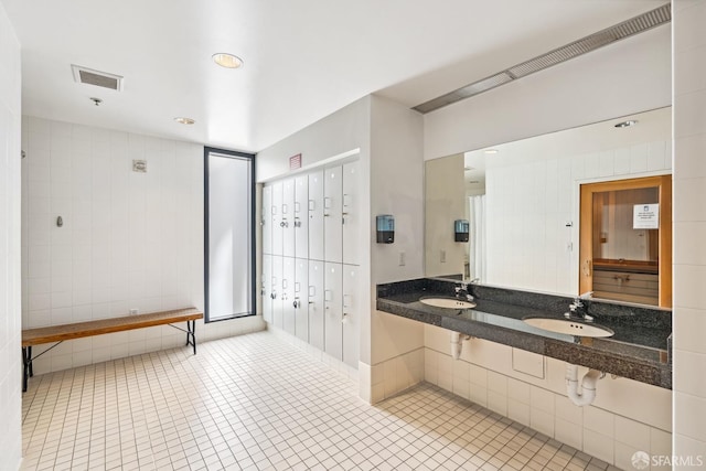 bathroom featuring double sink, tile patterned floors, tile walls, and a mail area