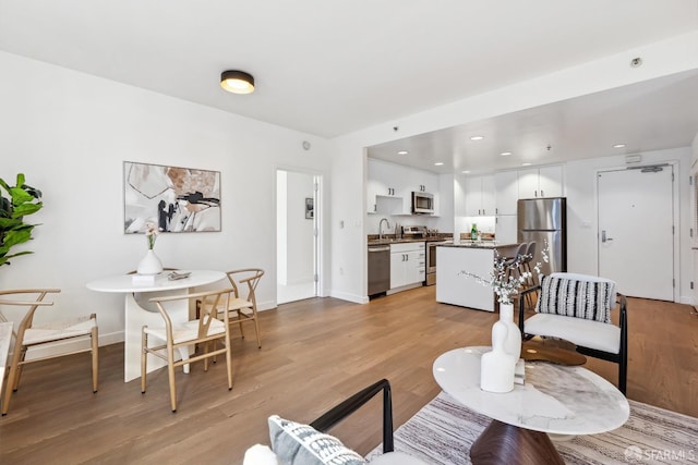 living room with sink and light wood-type flooring