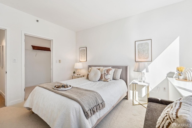 carpeted bedroom with a closet and a walk in closet