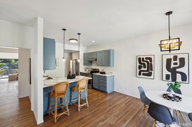 112 S Lake Merced Hls, San Francisco, CA 94132 - kitchen with electric range, a kitchen bar, a peninsula, dark wood-style flooring, and recessed lighting