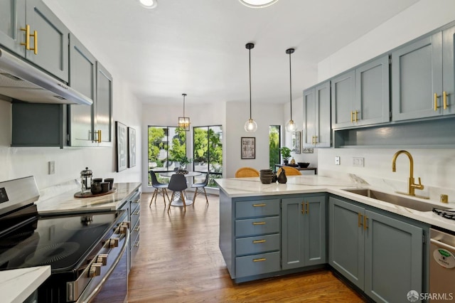 112 S Lake Merced Hls, San Francisco, CA 94132 - kitchen featuring appliances with stainless steel finishes, a sink, a peninsula, light stone countertops, and hanging light fixtures
