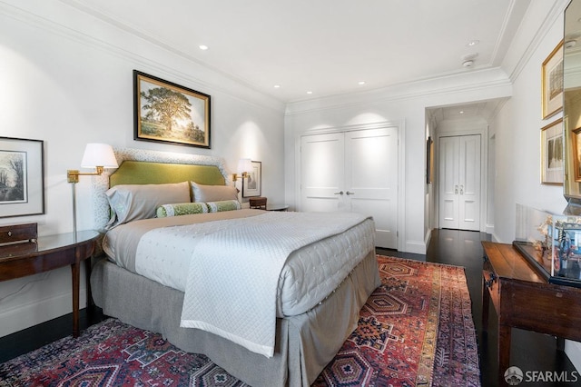 bedroom with a closet, crown molding, and dark hardwood / wood-style floors