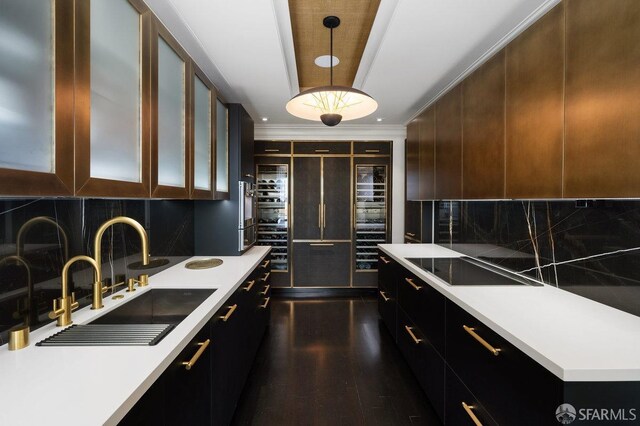 kitchen with crown molding, hanging light fixtures, black electric cooktop, sink, and backsplash