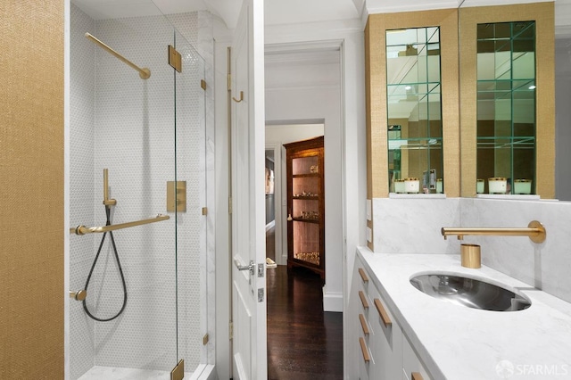 bathroom featuring vanity, backsplash, hardwood / wood-style floors, and a shower with door