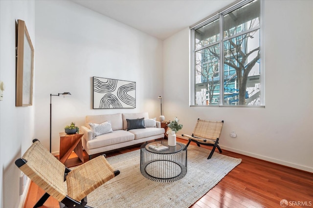 living room with wood-type flooring and baseboards