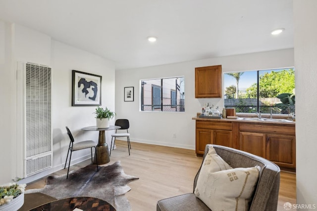 232 Talbert St, San Francisco, CA 94134 - kitchen with a heating unit, brown cabinets, light wood-type flooring, a sink, and baseboards