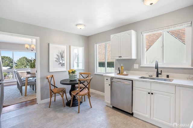 kitchen with a sink, baseboards, white cabinets, and stainless steel dishwasher