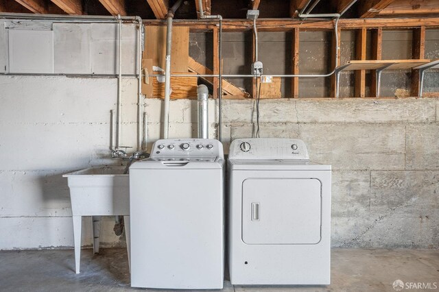 washroom with laundry area, a sink, and separate washer and dryer