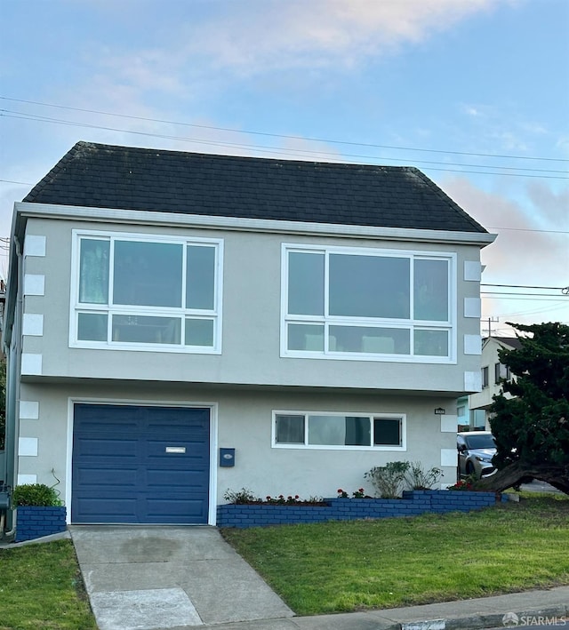 view of front of house with driveway, stucco siding, roof with shingles, an attached garage, and a front yard