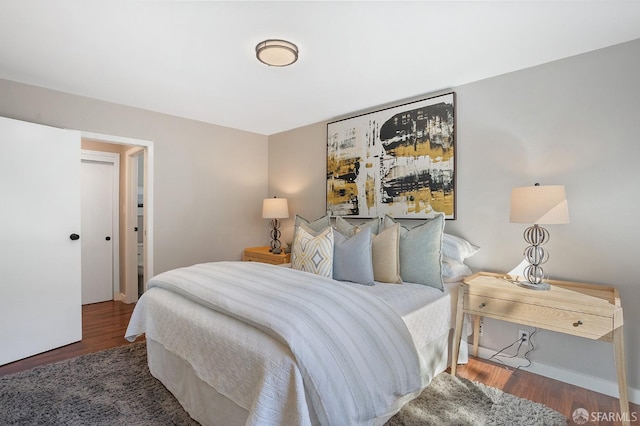 bedroom featuring baseboards and wood finished floors