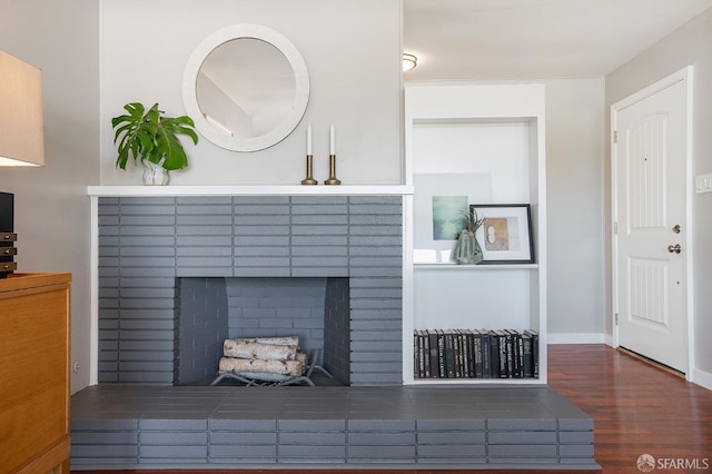 interior details with a fireplace, wood finished floors, and baseboards