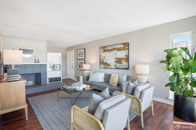 living room with visible vents, a fireplace, baseboards, and dark wood finished floors