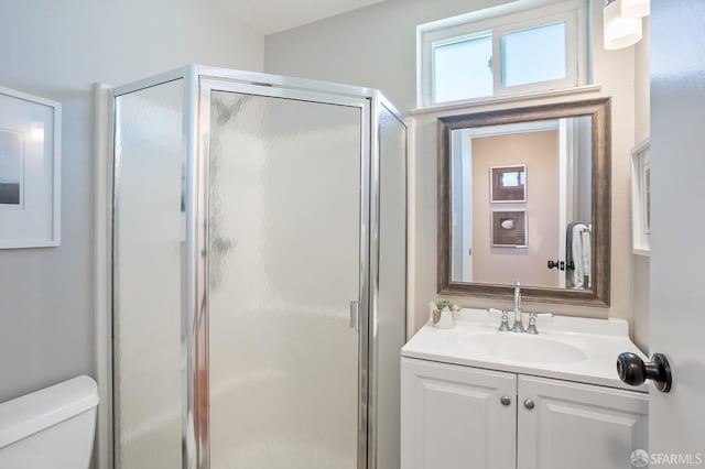 bathroom with a stall shower, vanity, and toilet