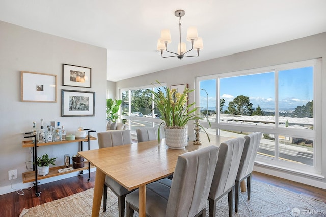 dining space featuring a wealth of natural light, a chandelier, and wood finished floors