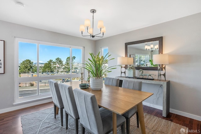 dining room with wood finished floors, baseboards, and an inviting chandelier