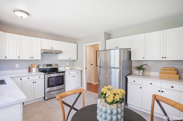 kitchen featuring under cabinet range hood, white cabinetry, and stainless steel appliances