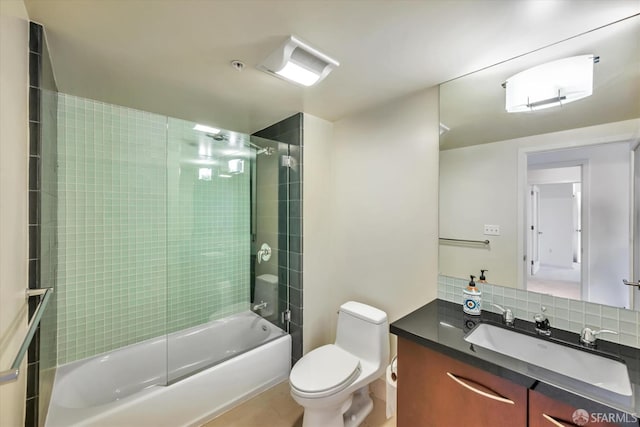 bathroom featuring toilet, vanity, decorative backsplash, and shower / bathing tub combination